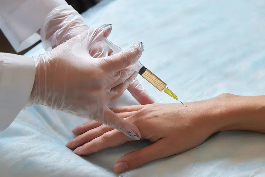 Physician performing PRP injection into hand joint using sterile technique